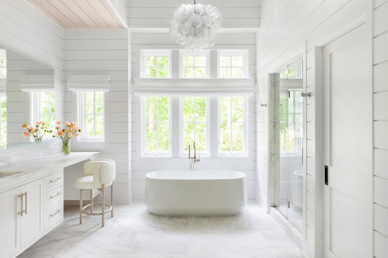 all white bathroom with coordinating vanity and chair