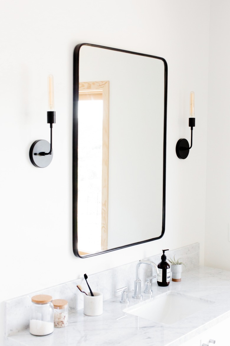 Faux candlestick-style bathroom vanity lighting ideas over marble vanity