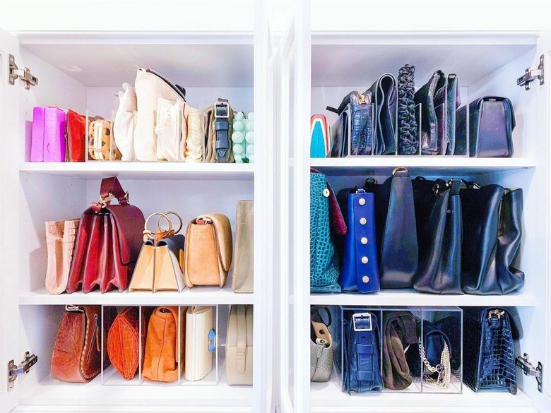 Close-up of closet shelving with purses sorted by color.