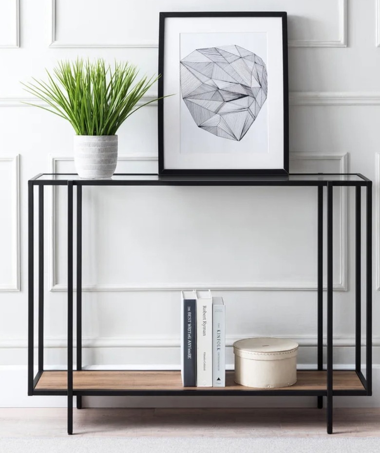 Black metal console table with glass and wood shelves