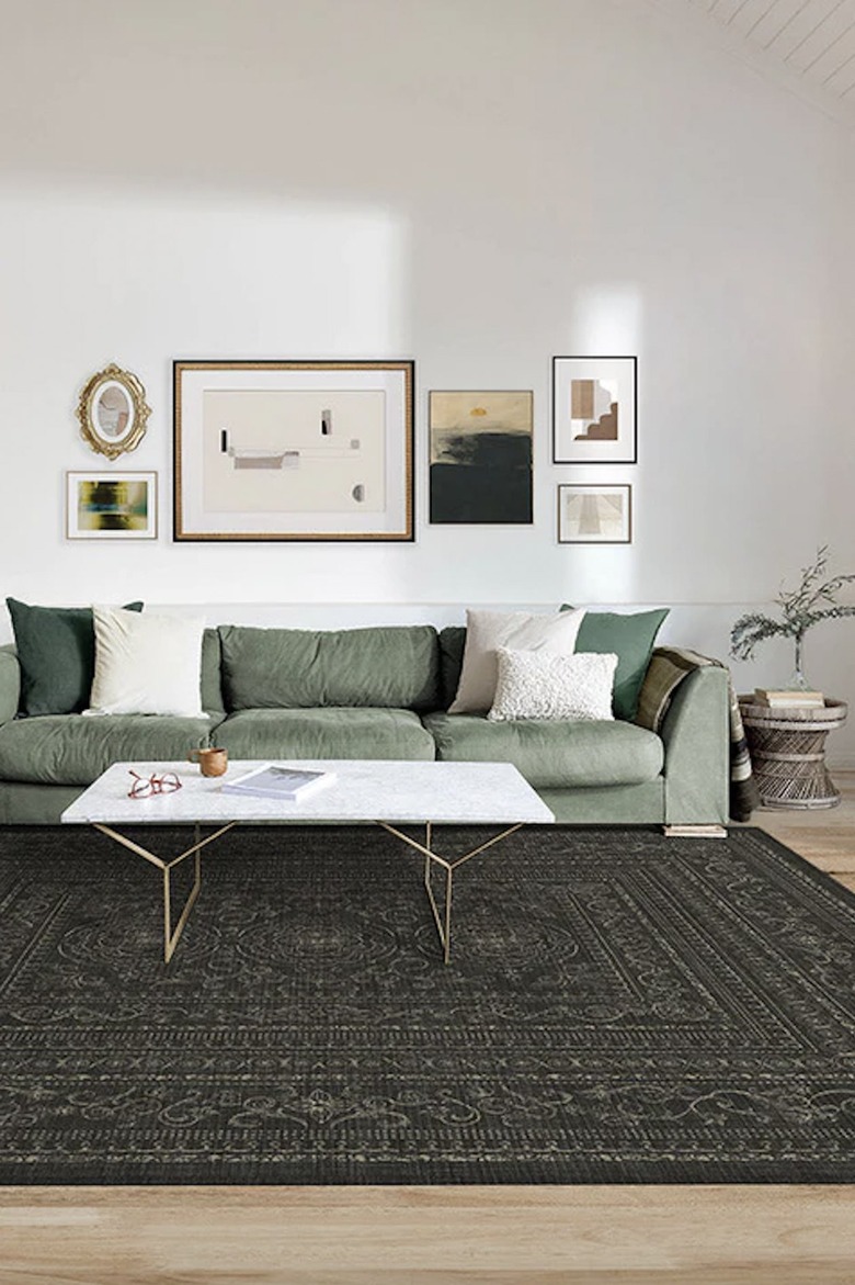 green couch with black rug beneath