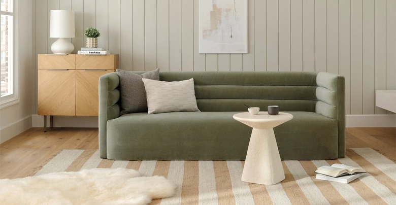 light sage green couch with striped jute rug