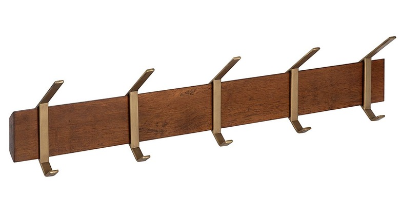 wall-mounted wood coat rack with gold hooks