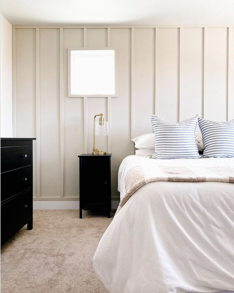 cream neutral colors in bedroom with black nightstand and dresser