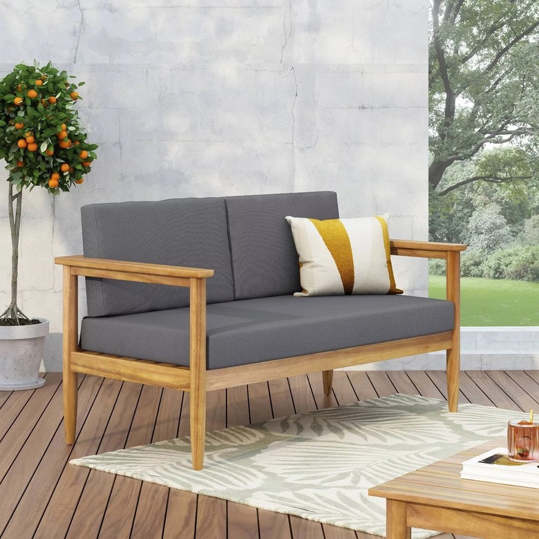 Outdoor loveseat with grey cushions and acacia wood