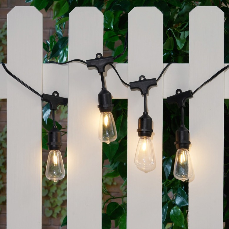 String lights on white picket fence