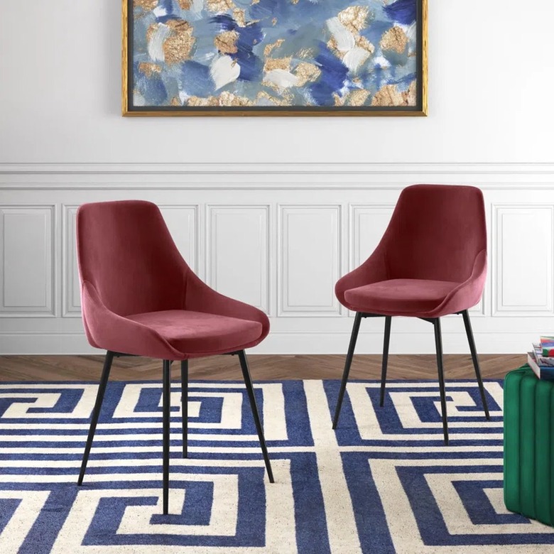 two pink velvet dining chairs with thin black legs