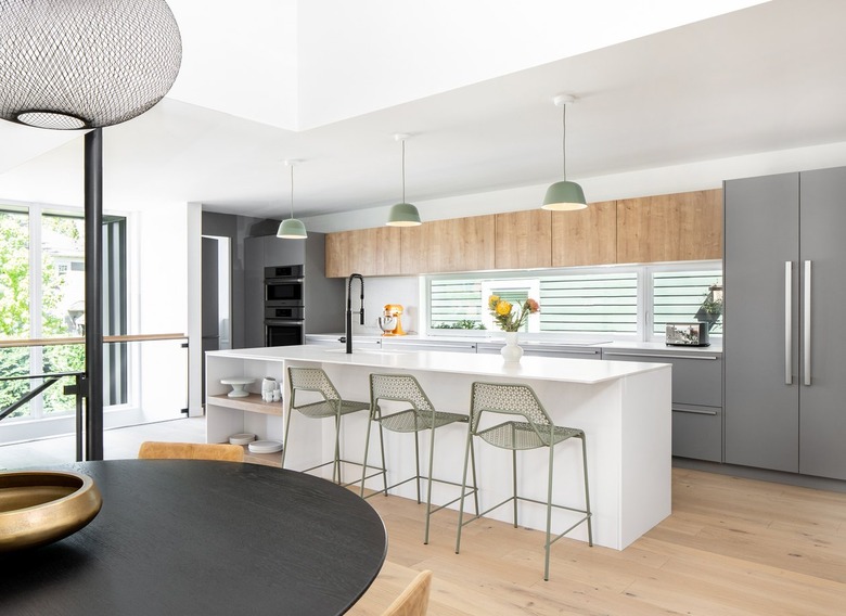 kitchen area with white island with chairs and gray refrigerator