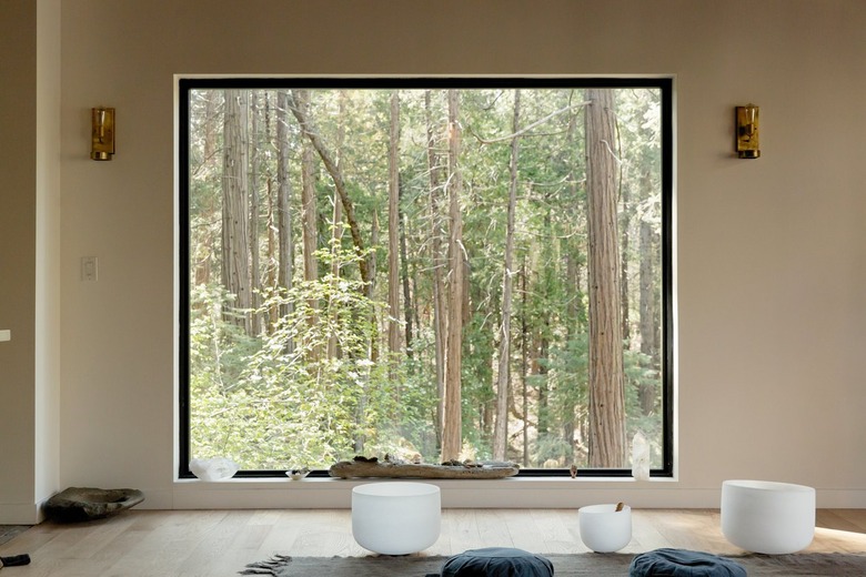 A large picture window with a forrest view