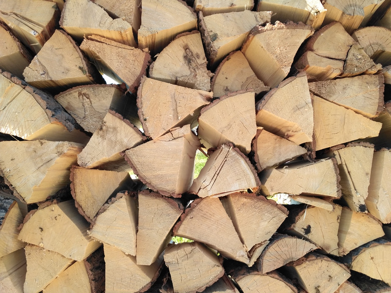 Chipped firewood is on the heap. Woodpile of firewood close-up. A stack of dry firewood