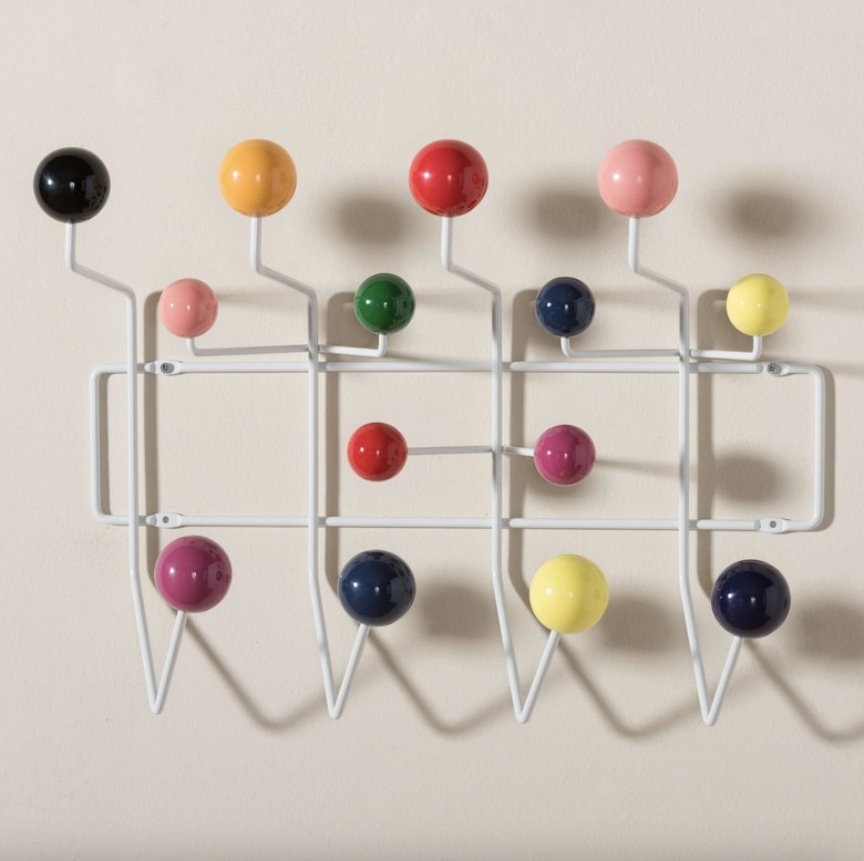 White hooks with colorful balls against a white wall