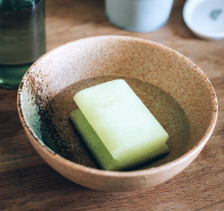Sponge sitting in water in ceramic bowl.