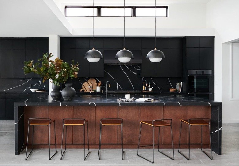 Black marble counter with dark brown kitchen island paneling.