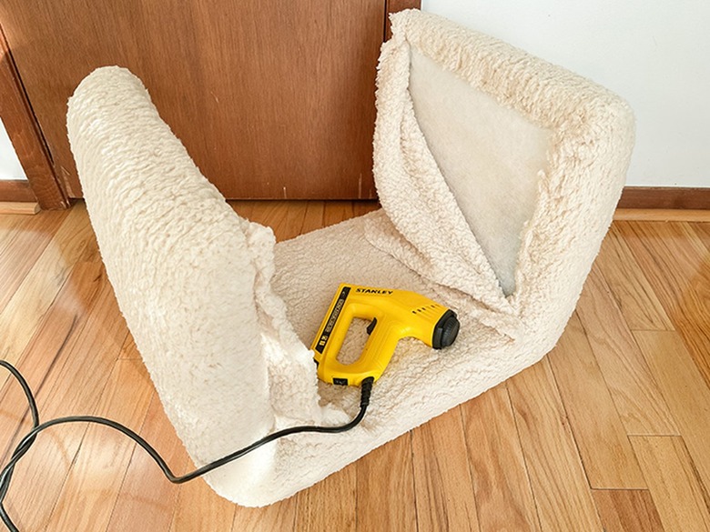 Upholster the stool form with fabric from a shearling blanket to finish.