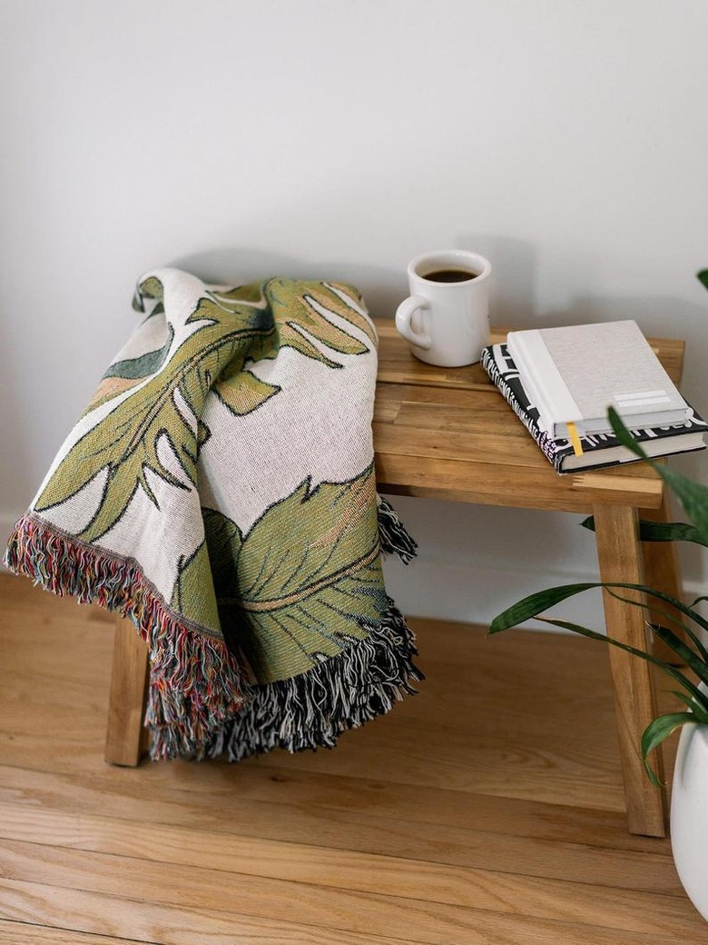 wood table with palm leaf print blanket