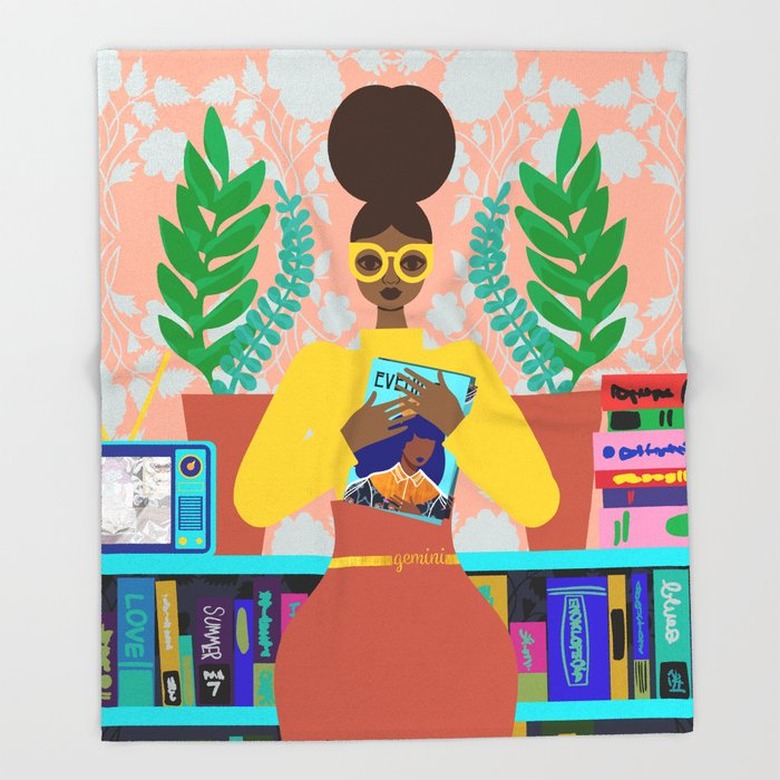 person standing with book in hand near bookshelves