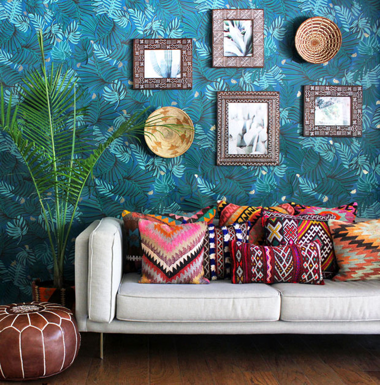 Bohemian blue living room with tropical wallpaper and patterned throw pillows