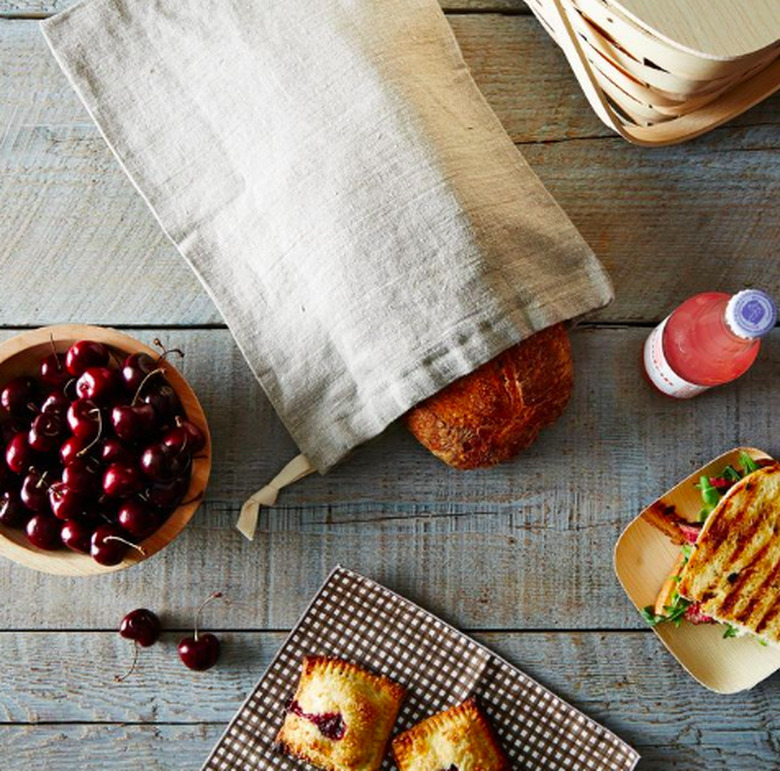 table with various foods and bread in linen bag