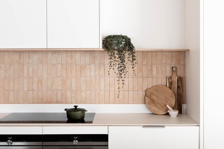 white kitchen with exposed vertical terra cotta brick backsplash