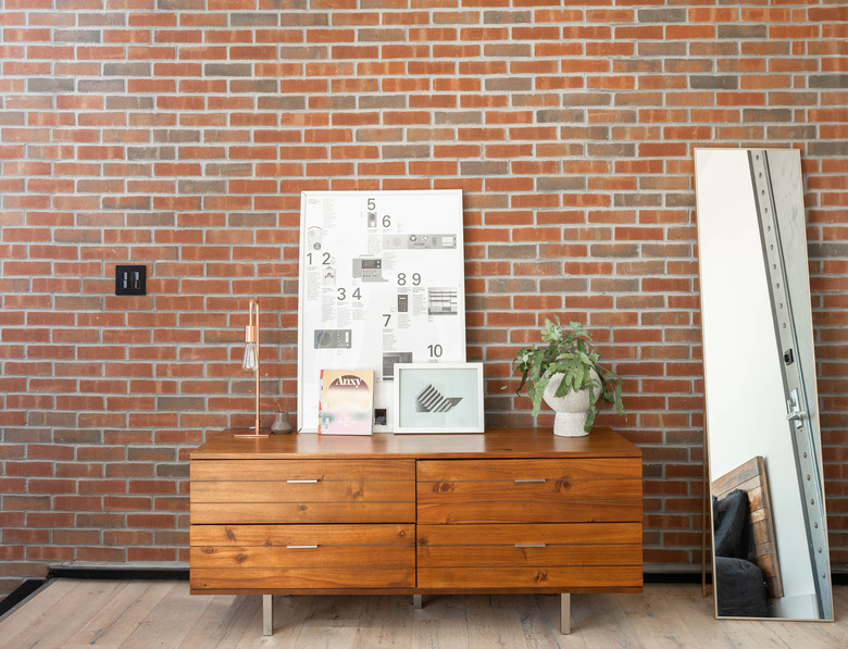 credenza in front of brick wall