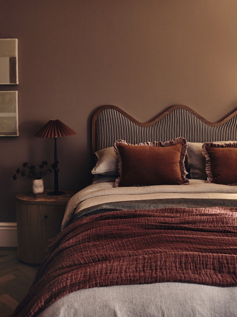 A brown bedroom with wavy headboard