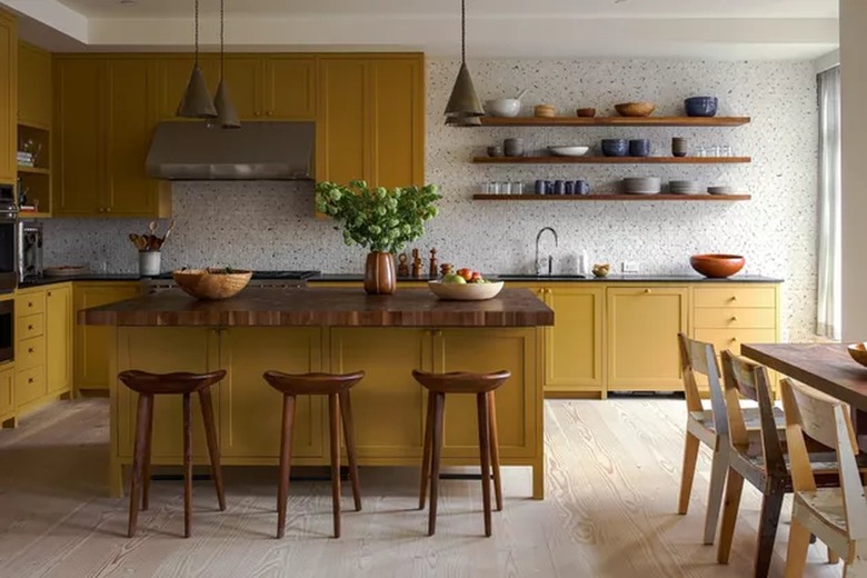 kitchen with yellow cabinets and black stone countertops