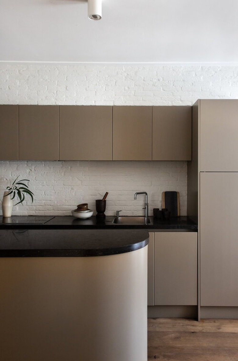 Ultra modern taupe kitchen cabinets with black counterops