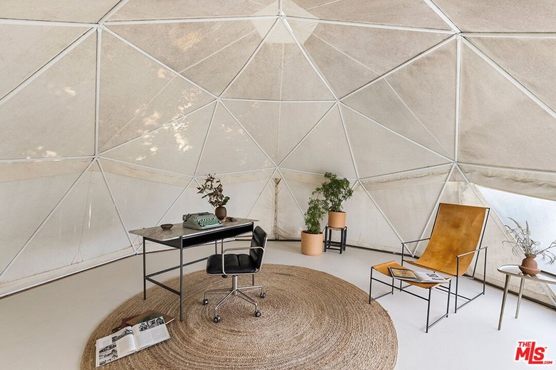 A dome-shaped room in cream with triangular panels with a desk