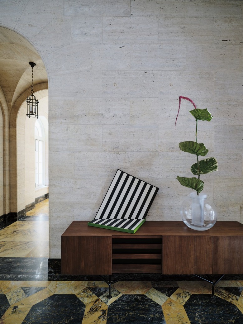 A walnut credenza with three drawers in ebonized black oak that pull out on smooth wood drawer glides while three cabinets open to reveal adjustable shelves. Set atop sleek black powdercoated legs