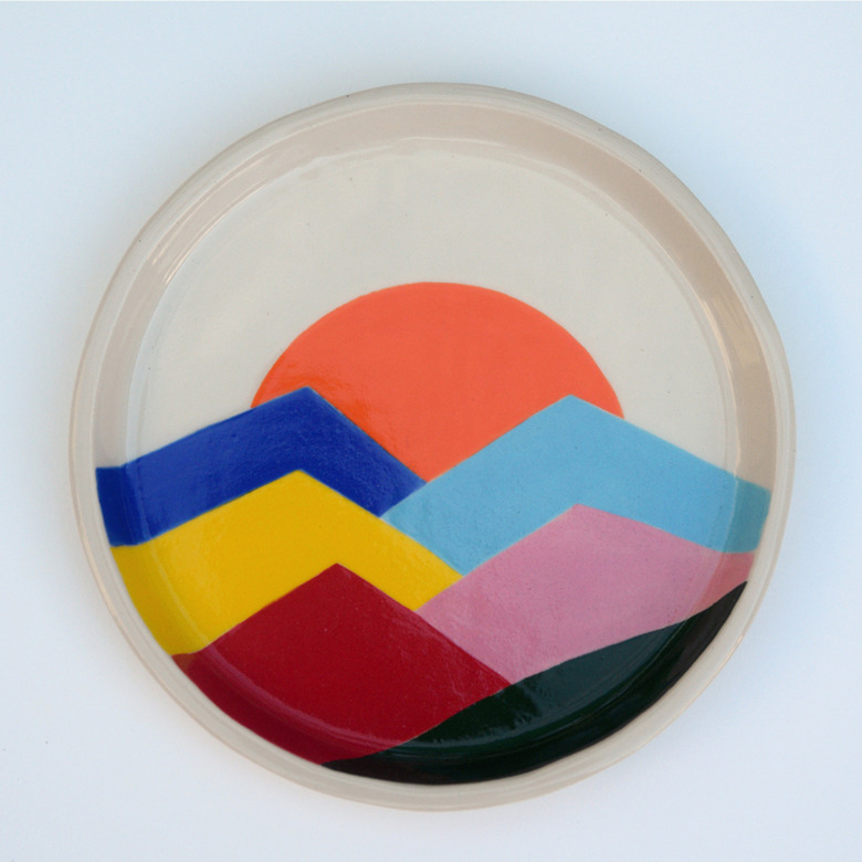 Plate with different colored mountains with the sunset.