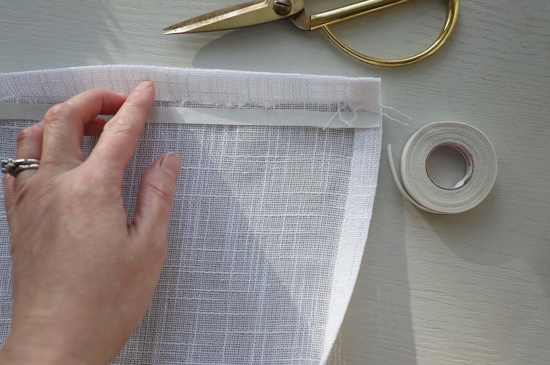 Placing strip of hemming tape under hem