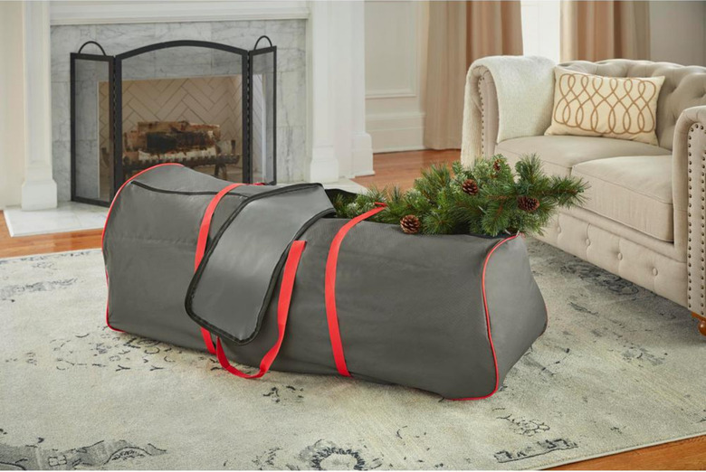 Gray and red Christmas tree storage bag with Christmas tree in living room