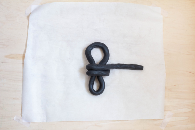 Tying knot around clay oval