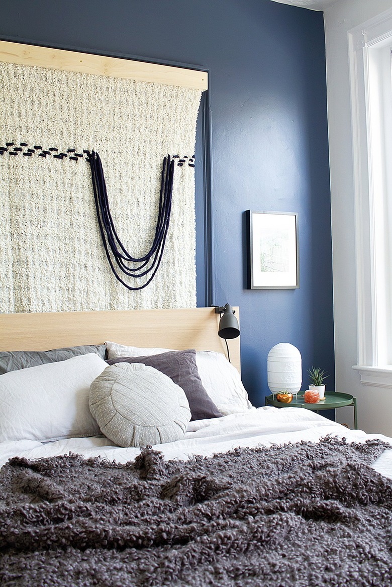 fabric wall hanging in bedroom with blue accent wall