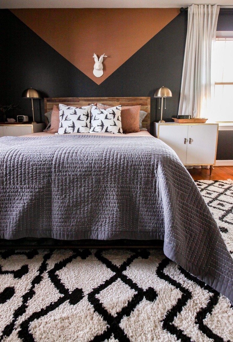 black and rust bedroom with geometric mural