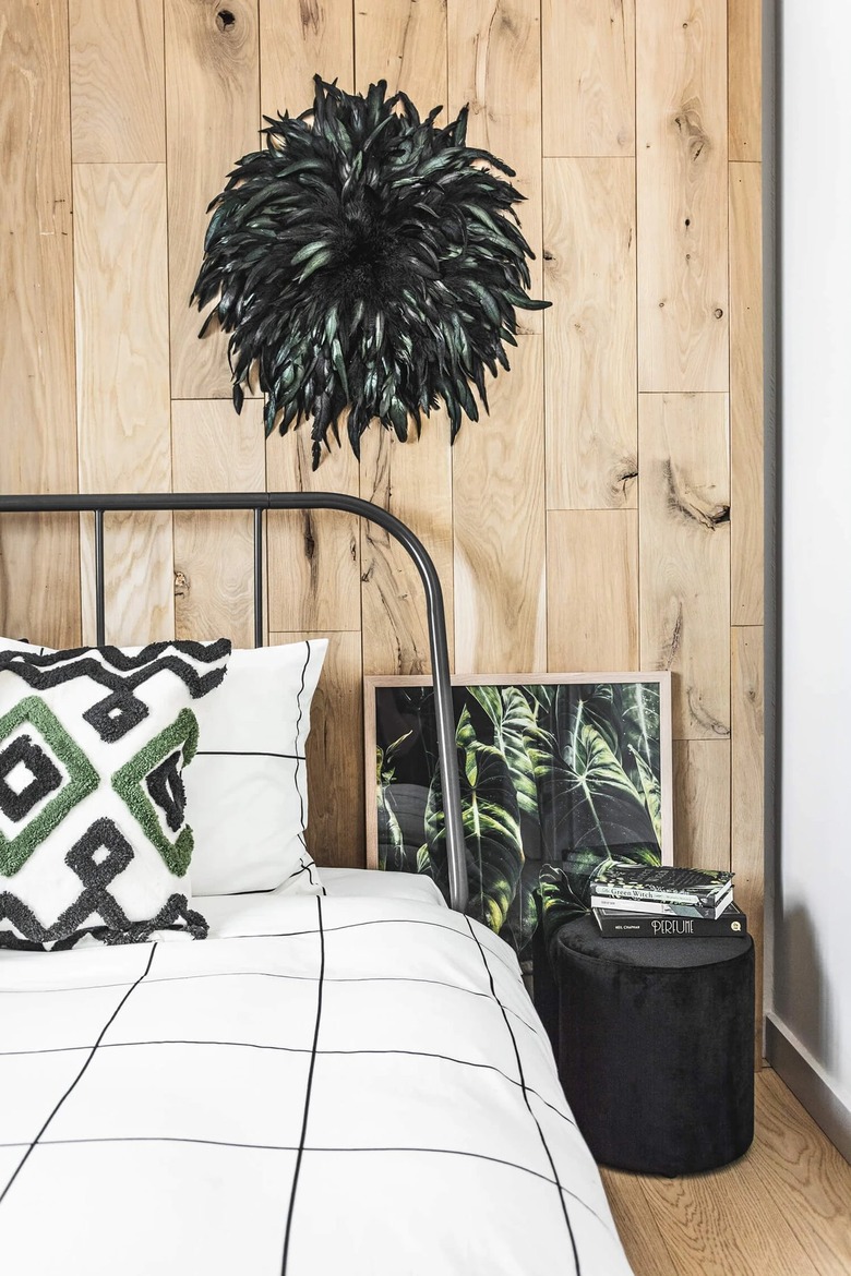 feather juju hat against wood paneling in bedroom