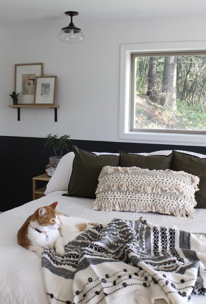boho bedroom with floating shelf and leaning artwork