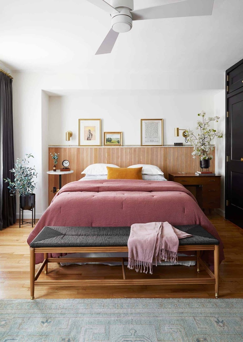 bedroom with wood detailing on wall and framed art