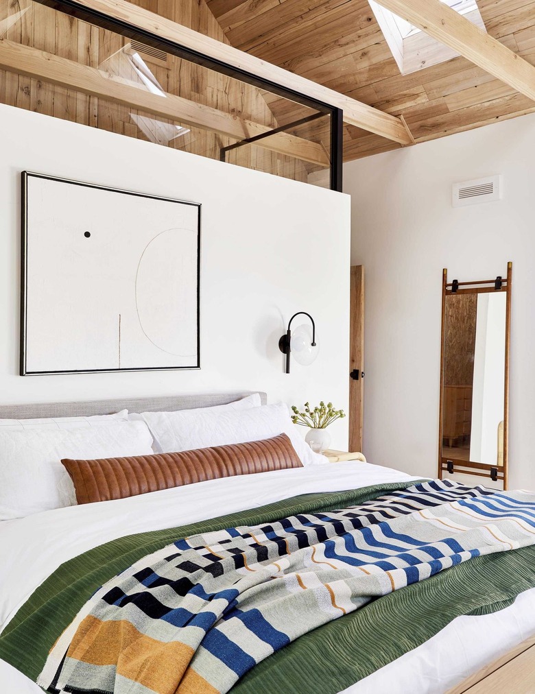 Scandinavian bedroom with modern artwork and sconce