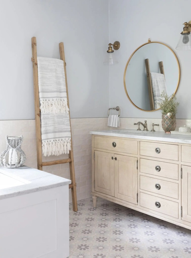 Coastal bathroom with wooden ladder holding towels.