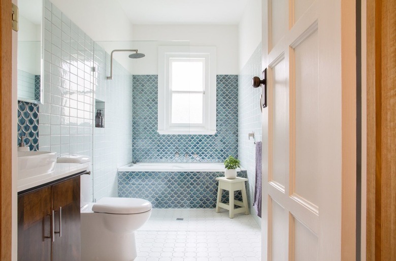 coastal bathroom with blue scallop tile bathtub