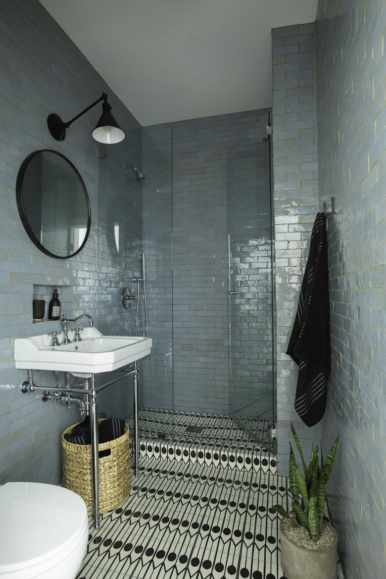 Bathroom with blue tiled walls and black and white tiled flooring