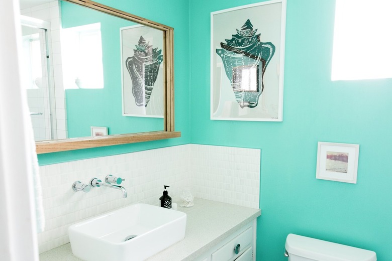 A bathroom with a turquoise wall