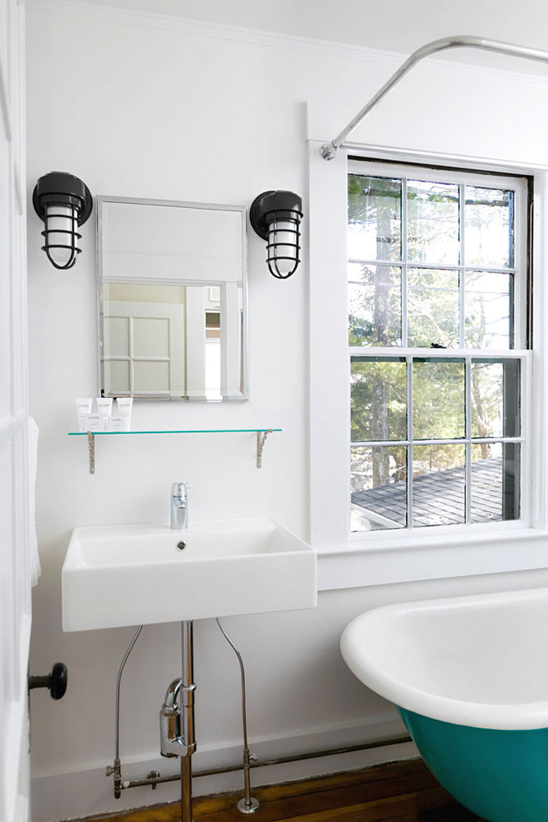 Industrial metal guard coastal bathroom lighting idea in white and turquoise bathroom