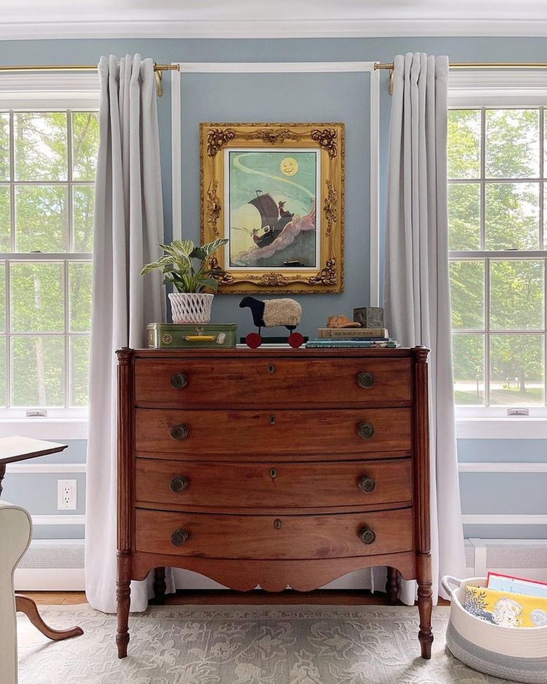 nursery with blue walls and vintage dresser