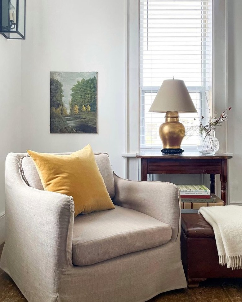 beige reading chair with yellow throw pillow