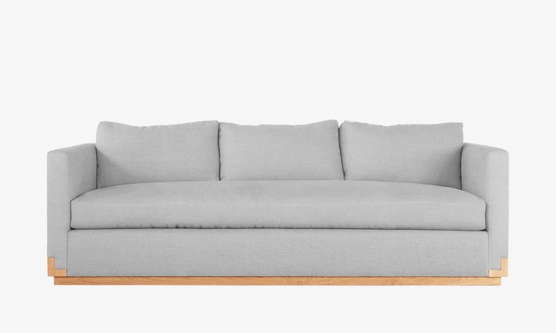 masculine coastal sofa with wood base detail in gray fabric