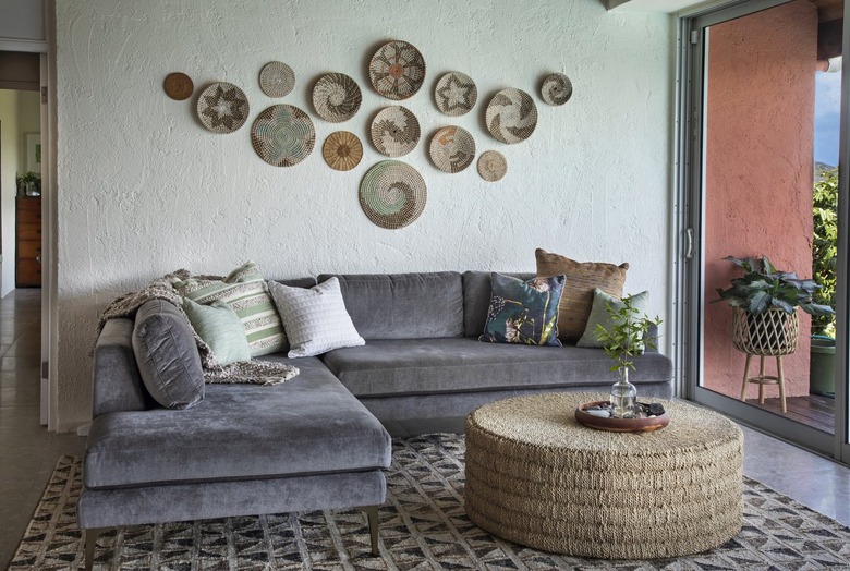 Gray couch with pillows against green wall