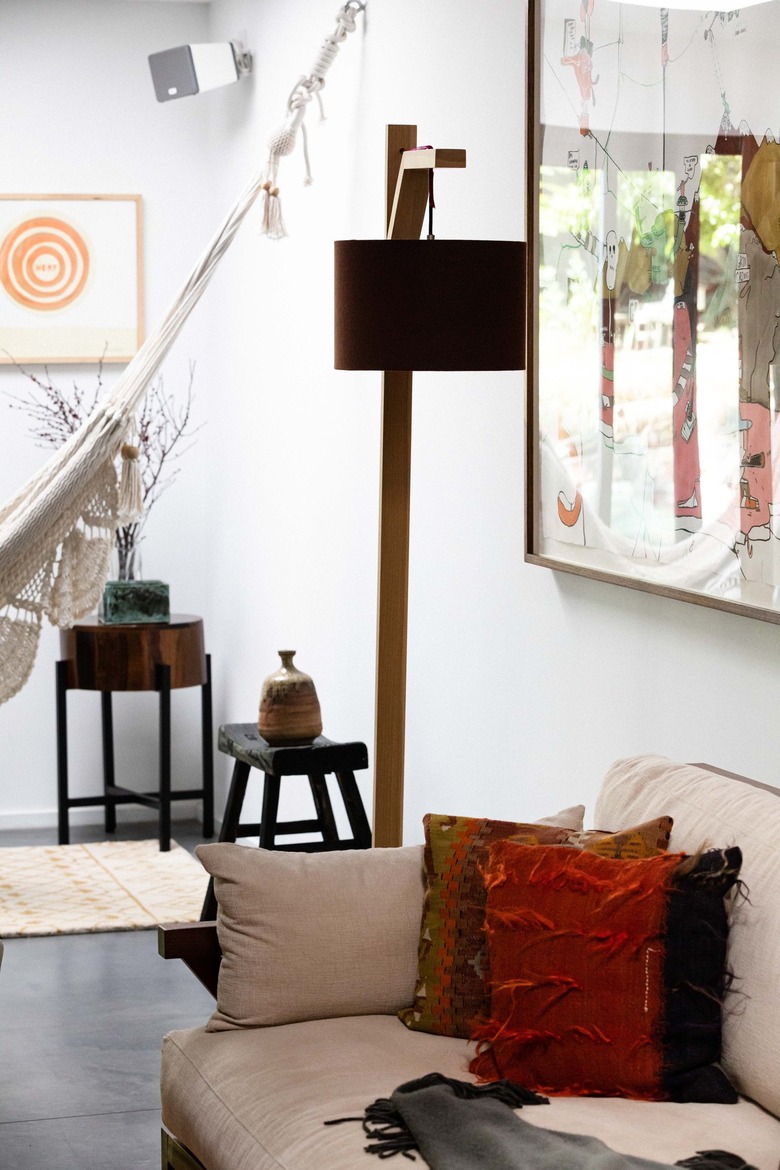 Blush-beige couch with pillows in white room with concrete flooring