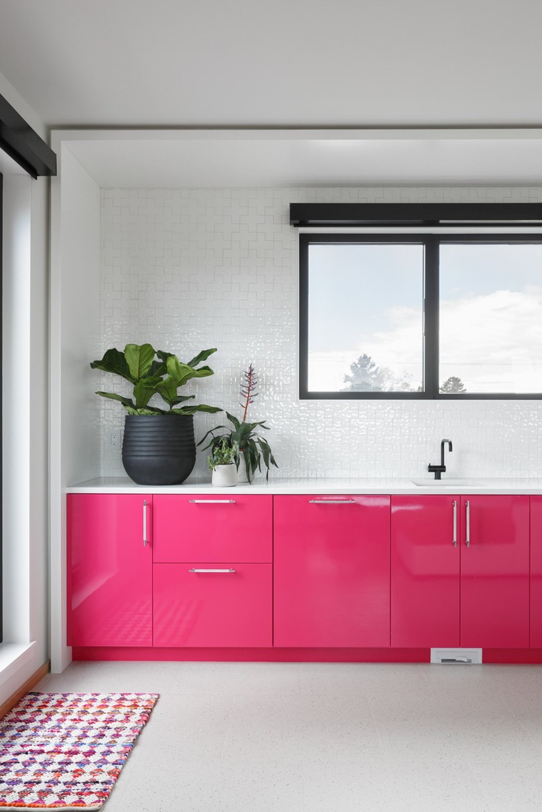 Hot pink cabinetry in white room with light gray flooring